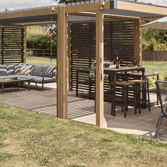 Outdoor patio area with wooden pergola, dining table, chairs, and umbrella.